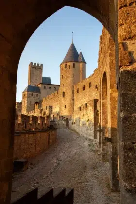 Visiter la cité de Carcassonne 5 Ruelle pavée et tour de la cité médiévale de Carcassonne, vues depuis une porte des remparts